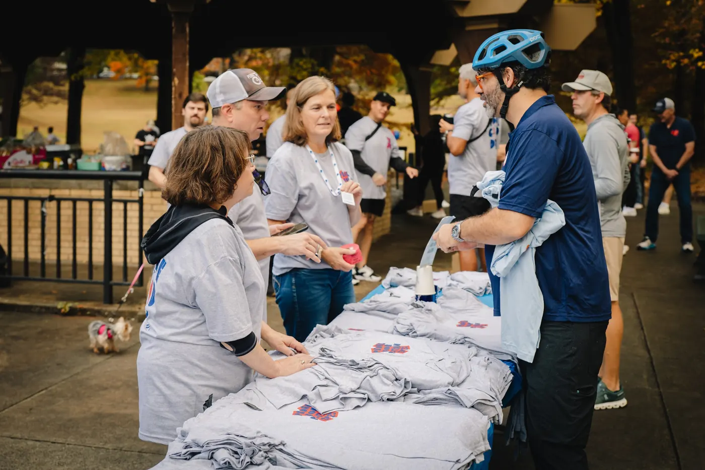 Participants gather around a table of event shirts at the 2025 ride.