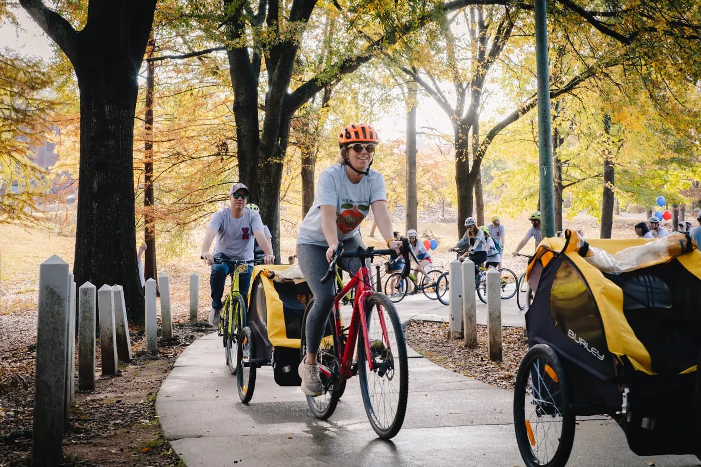 Cyclists and a bicycle trailer travel along the autumn path at the 2025 ride.